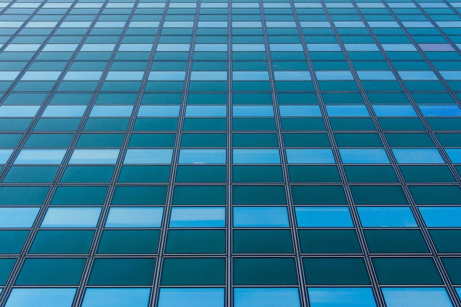 Moderno edificio per uffici con facciata in vetro che riflette il cielo